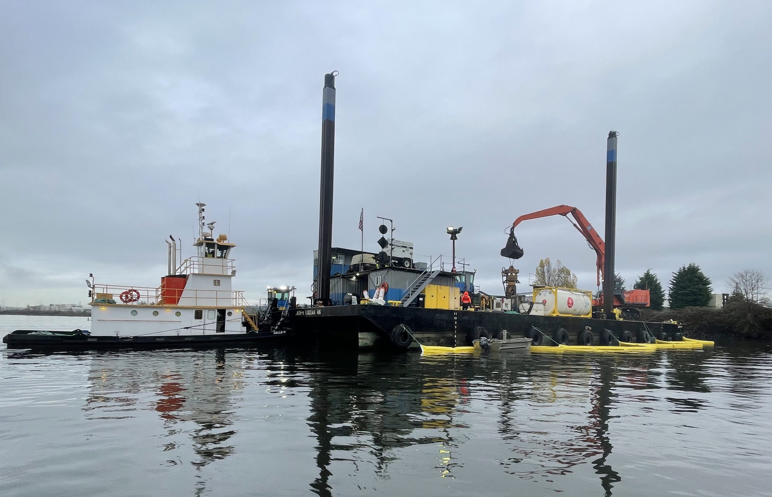 First day of construction on the upper reach. Tug boat next to a barge, which contains equipment.