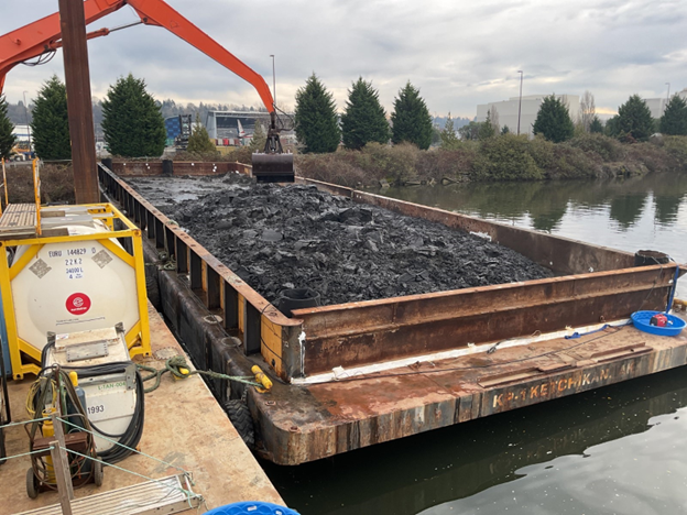 A barge holds excavated sediment from Sediment Management Area (SMA) 6. (Photo credit: Geosyntec)